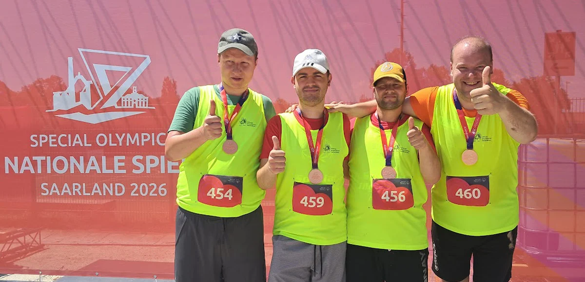 ier Staffelläufer mit Bronzemedaille in grellgelben Laufleibchen.