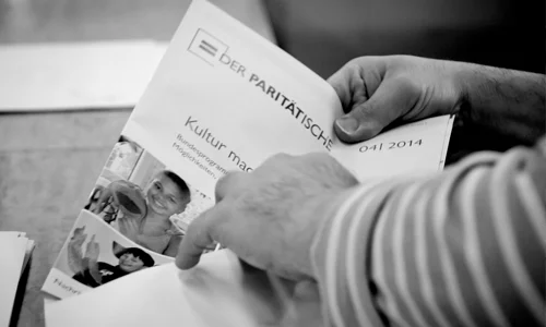 pw-lettershop-kachel Hände beim Eintüten einer Broschüre.